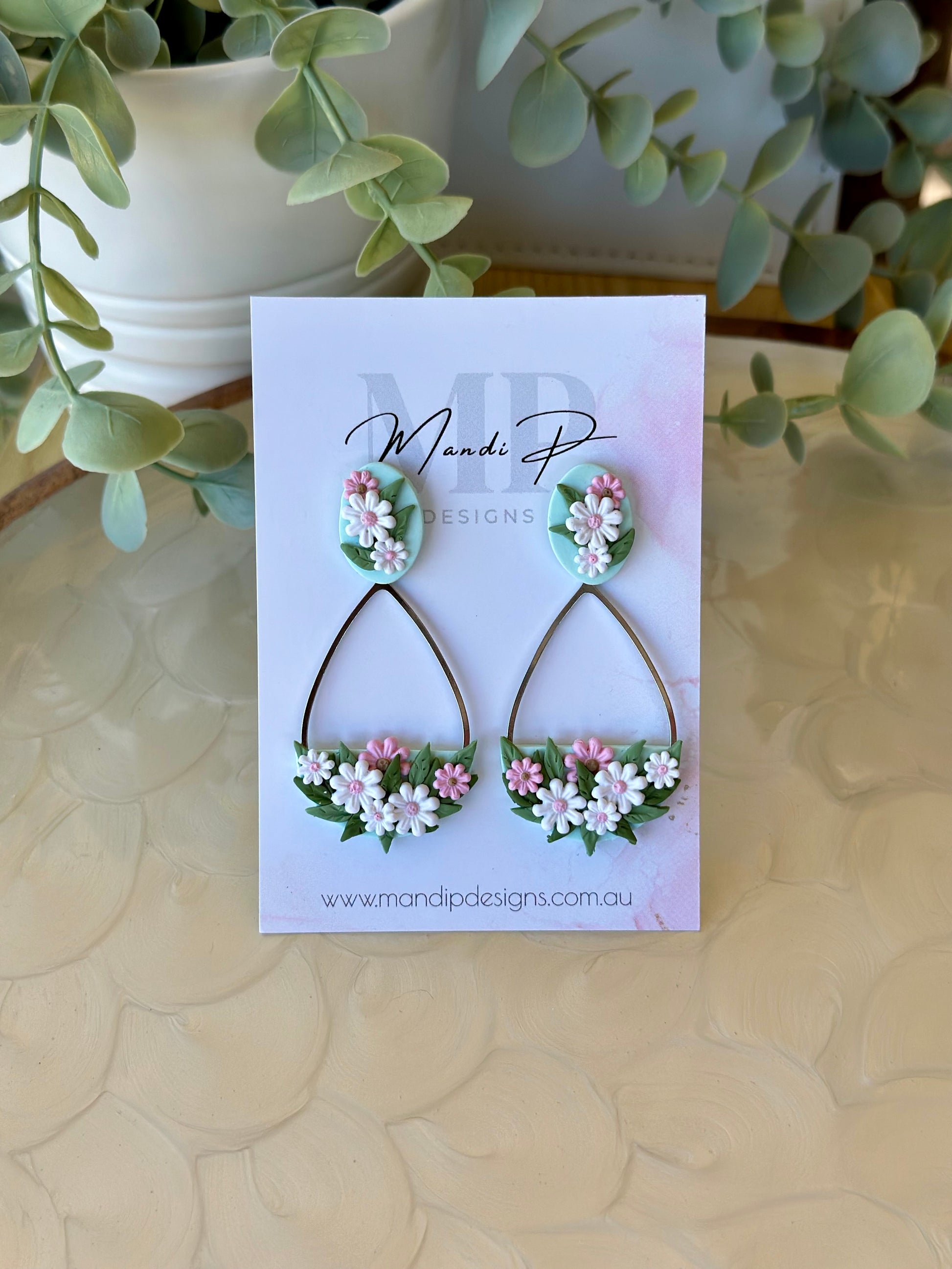 Handmade floral earrings with pink and white polymer clay daisies and green leaves on teardrop frame – Duelling Daisies Pink Daisy by Mandi P Designs
