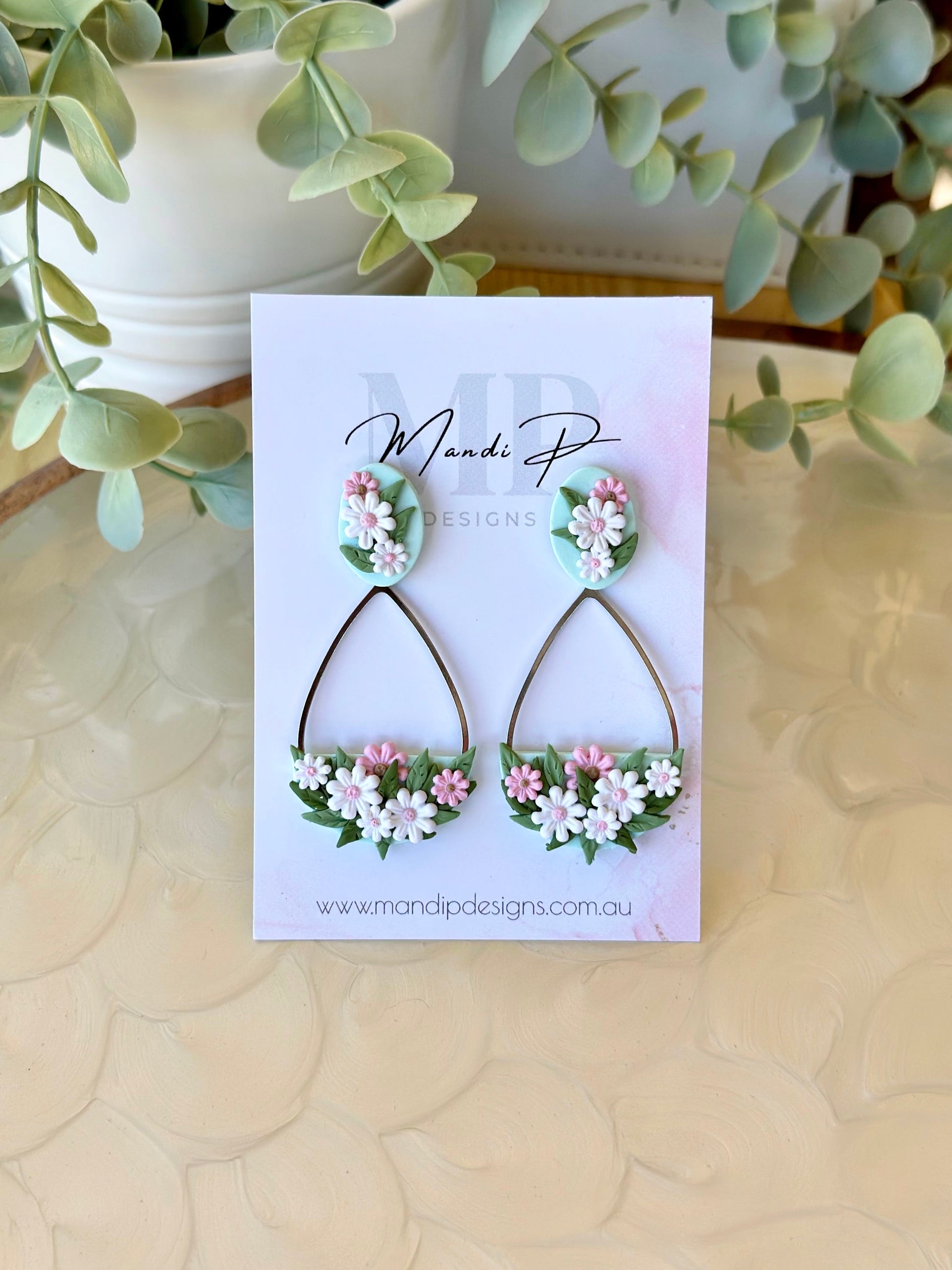 Handmade floral earrings with pink and white polymer clay daisies and green leaves on teardrop frame – Duelling Daisies Pink Daisy by Mandi P Designs