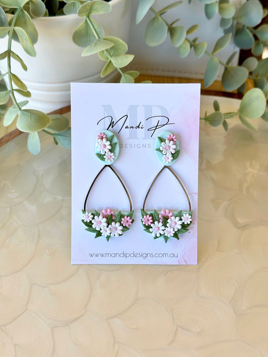 Handmade floral earrings with pink and white polymer clay daisies and green leaves on teardrop frame – Duelling Daisies Pink Daisy by Mandi P Designs